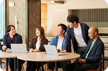 円卓を囲んで和やかにミーティングを行うPlusAのメンバー