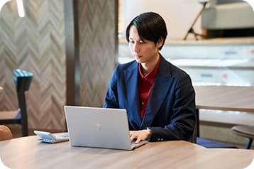 電卓とPCを使い集中して業務に取り組むスタッフ